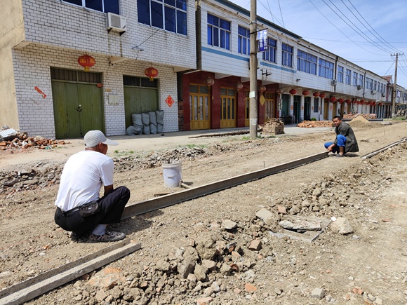 沭陽縣李恒鎮(zhèn)湯澗居委會(huì)中心路施工現(xiàn)場，工人正在進(jìn)行人行道立模，準(zhǔn)備鋪混凝土。丁華明 攝