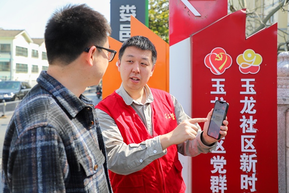 江蘇省昆山市物業(yè)人員向居民介紹“昆物通”電子投票系統(tǒng)使用方法。昆山市住建局供圖