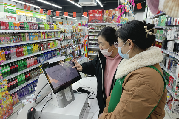 客戶經(jīng)理指導超市店員使用智能設備。連云港煙草供圖