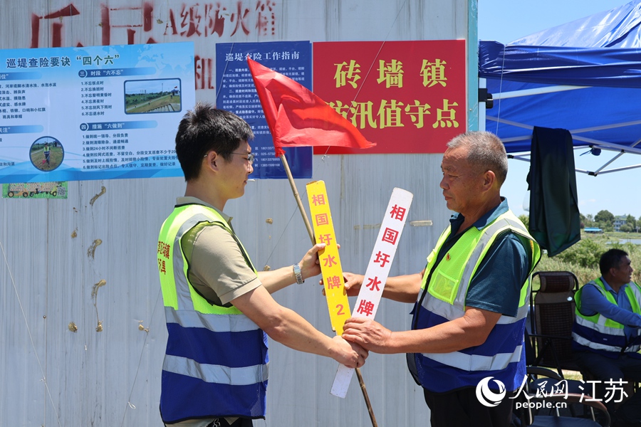 兩個防汛值守點(diǎn)的巡堤人員交換“水牌”。人民網(wǎng) 楊維瓊攝